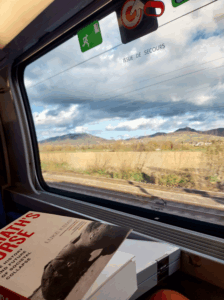 View out a train window in Spain with a book in the foreground.