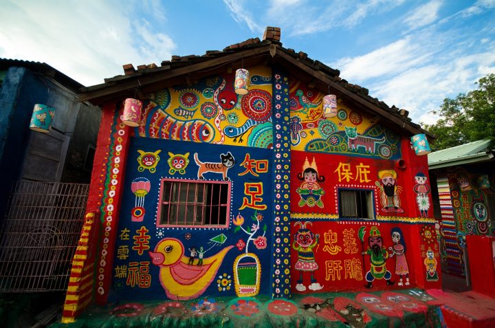 Värikkäin kuvioin maalattu pieni rakennus.
