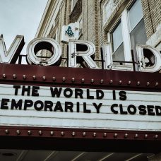 Elokuvateatterin mainoskyltin näköinen kyltti, jonka yläpuolella lukee "world" ja kyltissä "the world is temporarily closed".
