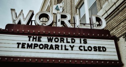 Elokuvateatterin mainoskyltin näköinen kyltti, jonka yläpuolella lukee "world" ja kyltissä "the world is temporarily closed".