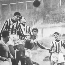 Mustavalkoinen kuva, jossa pelataan jalkapalloa.