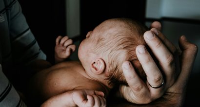 Person holding a baby.