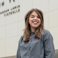 Liisa Pösö lähikuvassa Turun yliopiston päärakennuksen edessä.