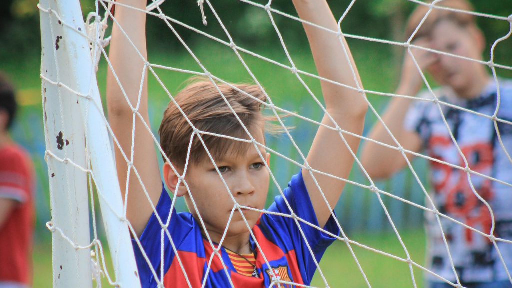 Verkon takana poika katsoo vakavana.