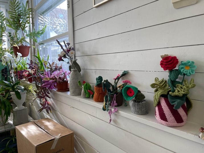Käsitöitä esillä hyllyllä.