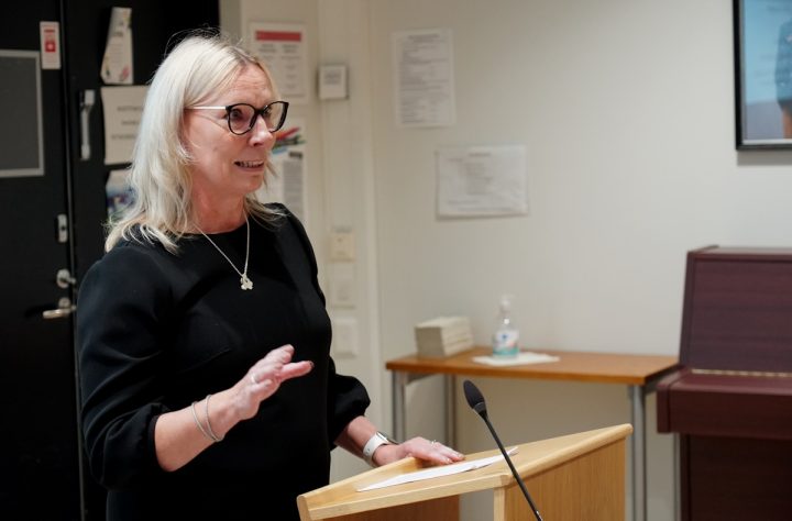 Nainen pitää puhetta puhujakorokkeella.