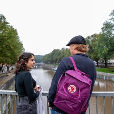 Nainen ja mies juttelemassa ulkona sillalla.