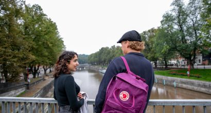 Nainen ja mies juttelemassa ulkona sillalla.