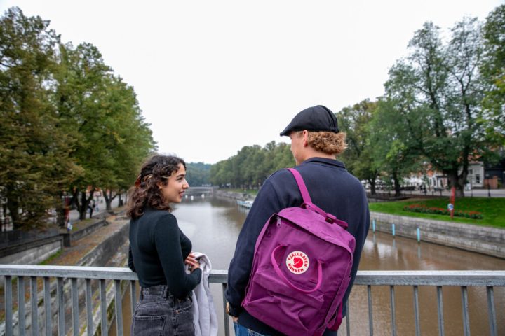 Nainen ja mies juttelemassa ulkona sillalla.