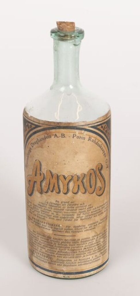 Lasinen amykos-pullo, jossa on korkki ja ruskeansävyinen etiketti.