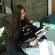 Turun yliopistossa kahta tutkintoa suorittava opiskelija lukee lehteä kampuksen sohvalla.