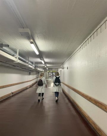 Lääketieteen opiskelijat kävelevät tunnellissa poispäin kamerasta.