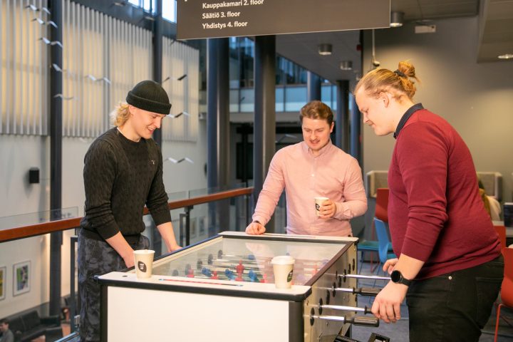 Kolme opiskelijaa pelaa pöytäjalkapalloa Turun kauppakorkeakoululla.