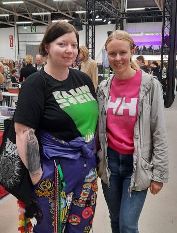 Opiskelijahaalareihin pukeutunut henkilö poseeraa kaverinsa kanssa Turun kirjamessuilla.