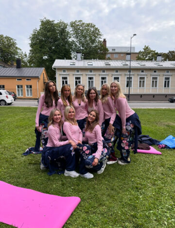 Ryhmä ihmisiä vaaleanpunaiset verryttelytakit päällä ulkona