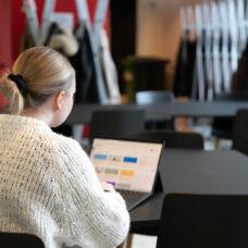 Opiskelija opiskelemassa läppärillä yliopiston aulatiloissa.