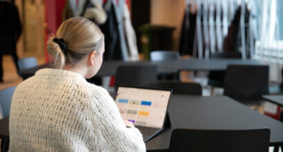 Opiskelija opiskelemassa läppärillä yliopiston aulatiloissa.