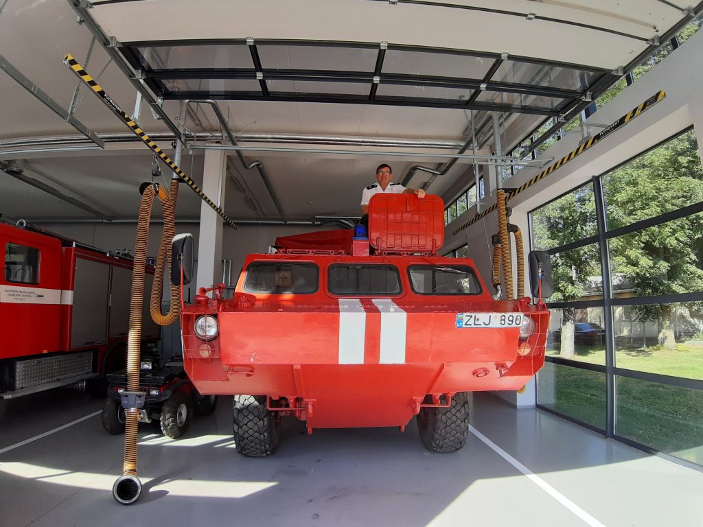 A man on top of a red and white painted tank