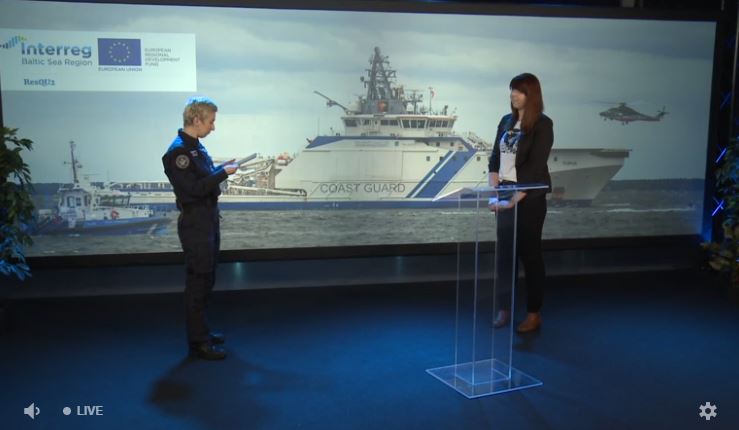 Two women in an interview situation in front of a picture of two vessels and a helicopter.