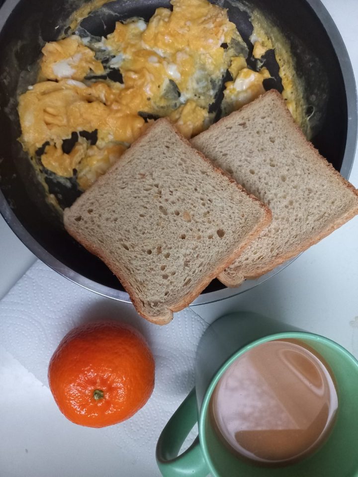 Coffee, scrambled eggs, clementine, and coffee