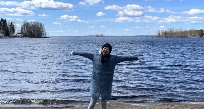 Writer Hinako Matsui standing in front of a beautiful lake and smiling
