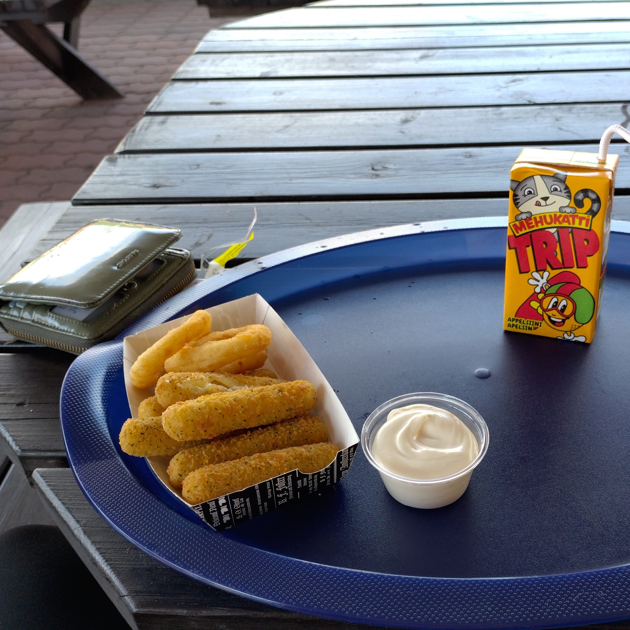 mozarella sticks, mayonnaise and juice on a restaurant table in turku 