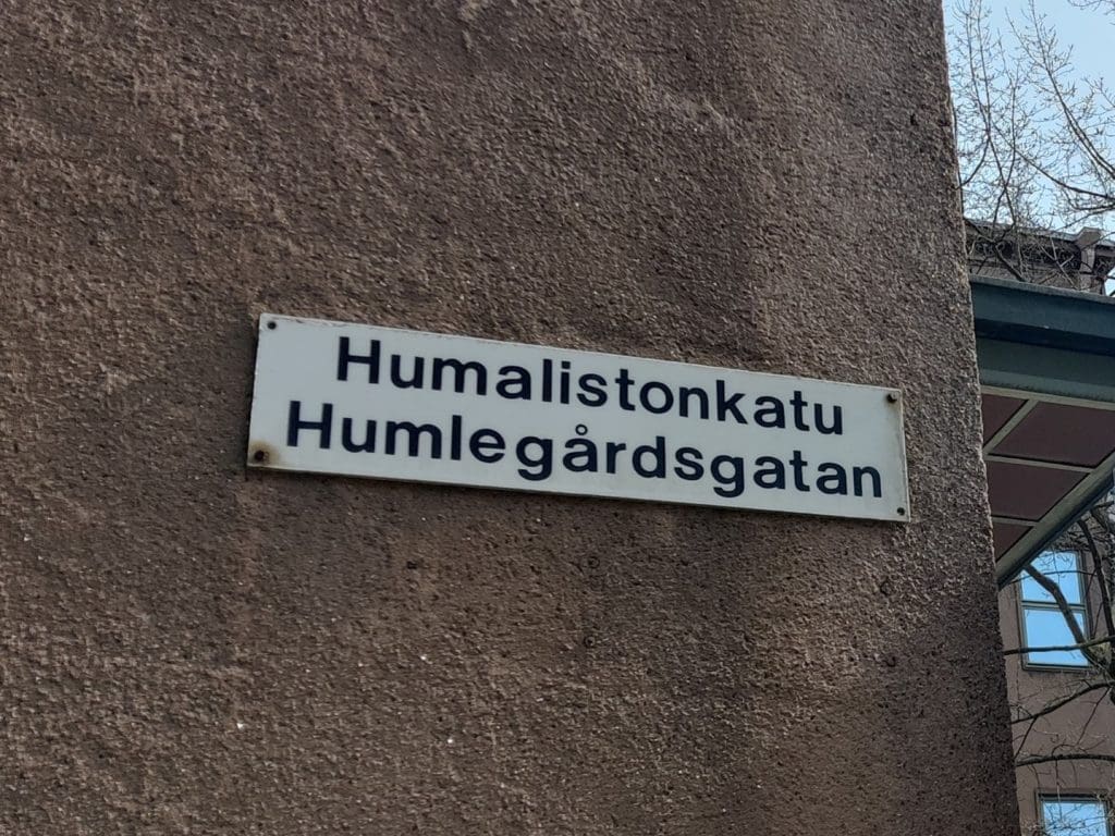 Kyltti, jossa lukee suomeksi Humalistonkatu ja ruotsiksi Humlegårdsgatan.